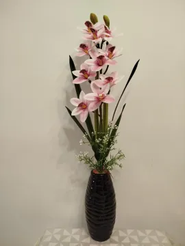 Rózsaszín cymbidium orchidea művirág fekete bordázott vázában
