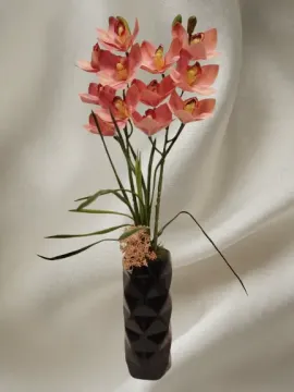 Rózsaszín cymbidium orchidea, fekete bordázott vázában